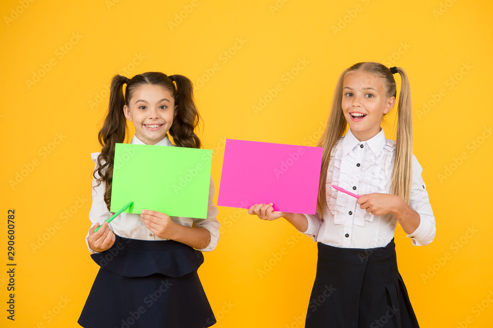 Important lesson you should learn. Cute small children reciting lesson with pen and paper on yellow background. Little girls having lesson in writing. Using exciting ideas in the lesson, copy space Important lesson you should learn. Cute small children reciting lesson with pen and paper on yellow background. Little girls having lesson in writing. Using exciting ideas in the lesson, copy space