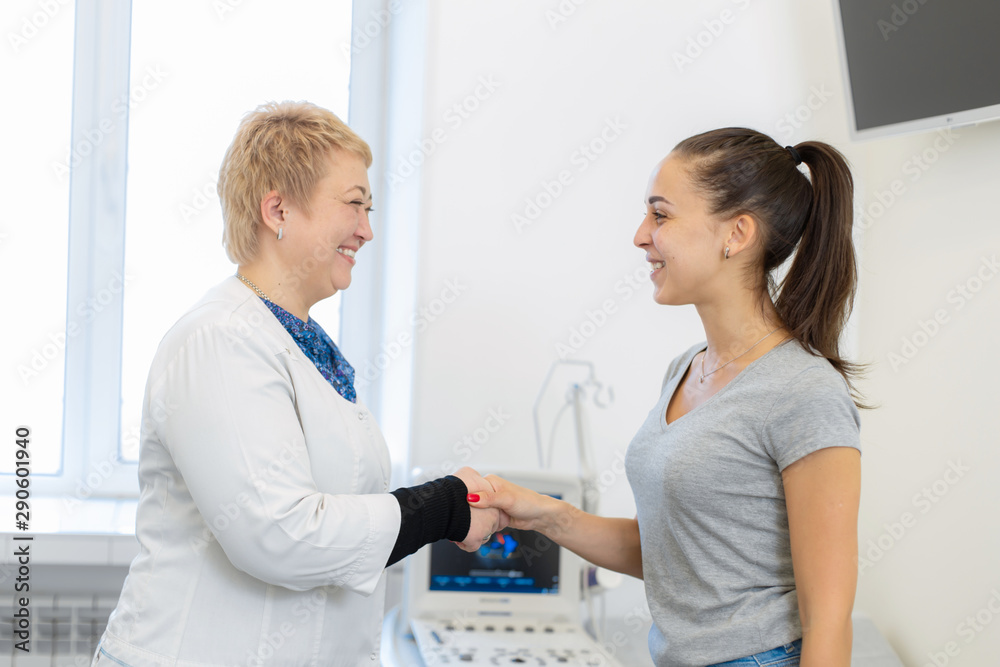 Obraz premium A young girl patient thanked the doctor for the consultation and shakes his hand goodbye