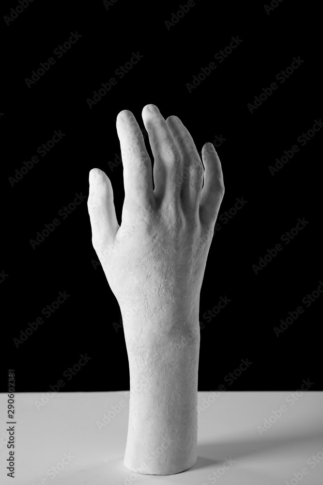Fototapeta premium elegant white plaster hand on a black background
