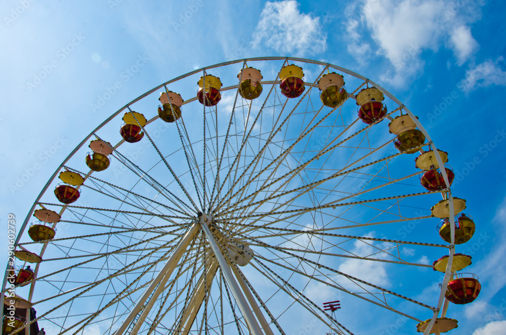 A colourful ferris wheel carousel at a fun fair by daylight in the sun A colourful ferris wheel carousel at a fun fair by daylight in the sun