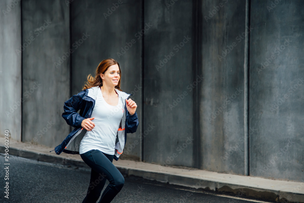 Side View Of A Smiling Young Woman Running On The Street. Urban life. Side View Of A Smiling Young Woman Running On The Street. Urban life.
