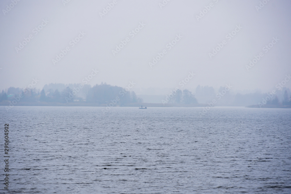 Landscape with a lake during the fog mist; plants water boats fishing view, beautiful sky clouds calm leisure reeds