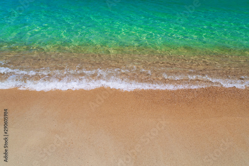 Ocean turquoise  yellow sand  waves  sunlight.