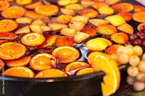 Fotografía Hot mulled wine drink with citrus, cinnamon sticks, cloves and anise in cooking