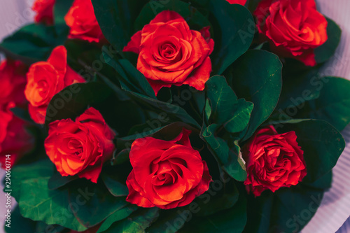 bunch of Red and pink roses with  rose bouquet at dining restaurant. Soft focus  top view displayed   luxury jewelry love gift on Valentines Day and romantic holidays