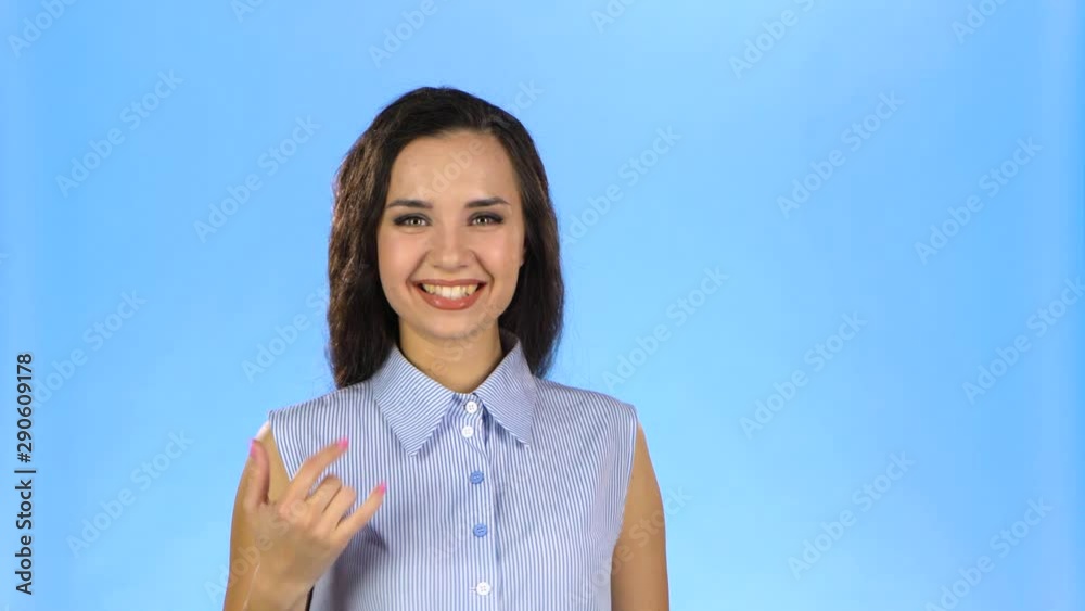 Woman is making rock gesture and showing her tongue Woman is making rock gesture and showing her tongue