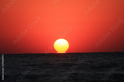 Fototapeta Naklejka Na Ścianę i Meble -  the sun like a ball coming out of the sea
