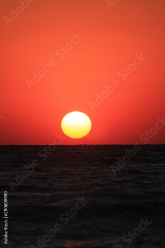 a sunrise at the seashore in red colors