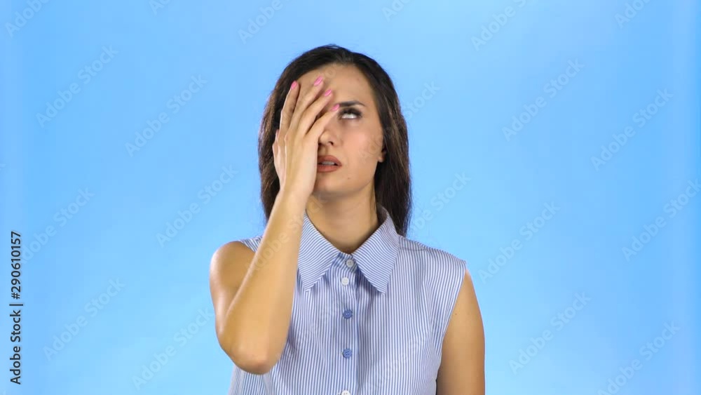 Young lady is shocked and dissapointed making facepalm and rolling eyes Young lady is shocked and dissapointed making facepalm and rolling eyes