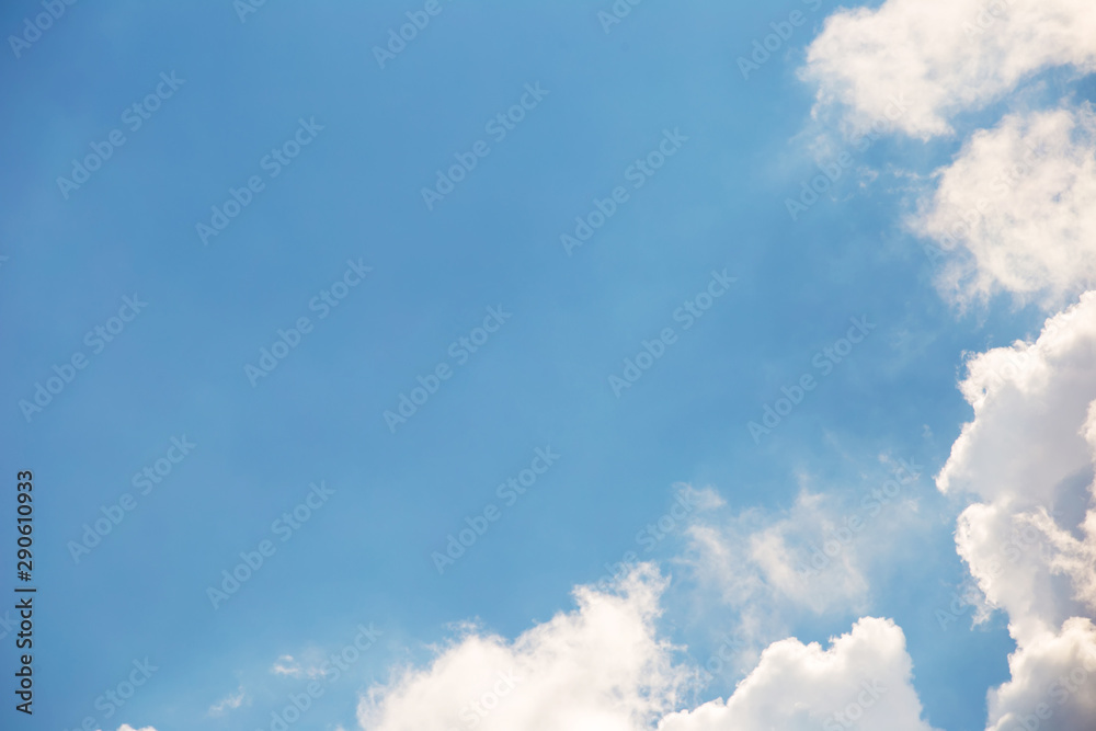 Blue sky background. White fluffy clouds on a background of clear blue sky. Clouds in the corner of the background Blue sky background. White fluffy clouds on a background of clear blue sky. Clouds in the corner of the background