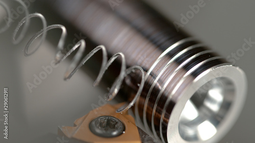 MACRO, DOF: Sharp cutter carves a thread into a small metal rod during threading photo