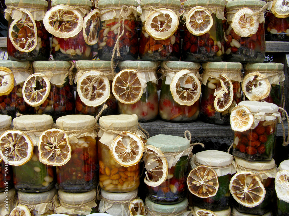 Honey with nuts in jars decorated with dried lemon. 