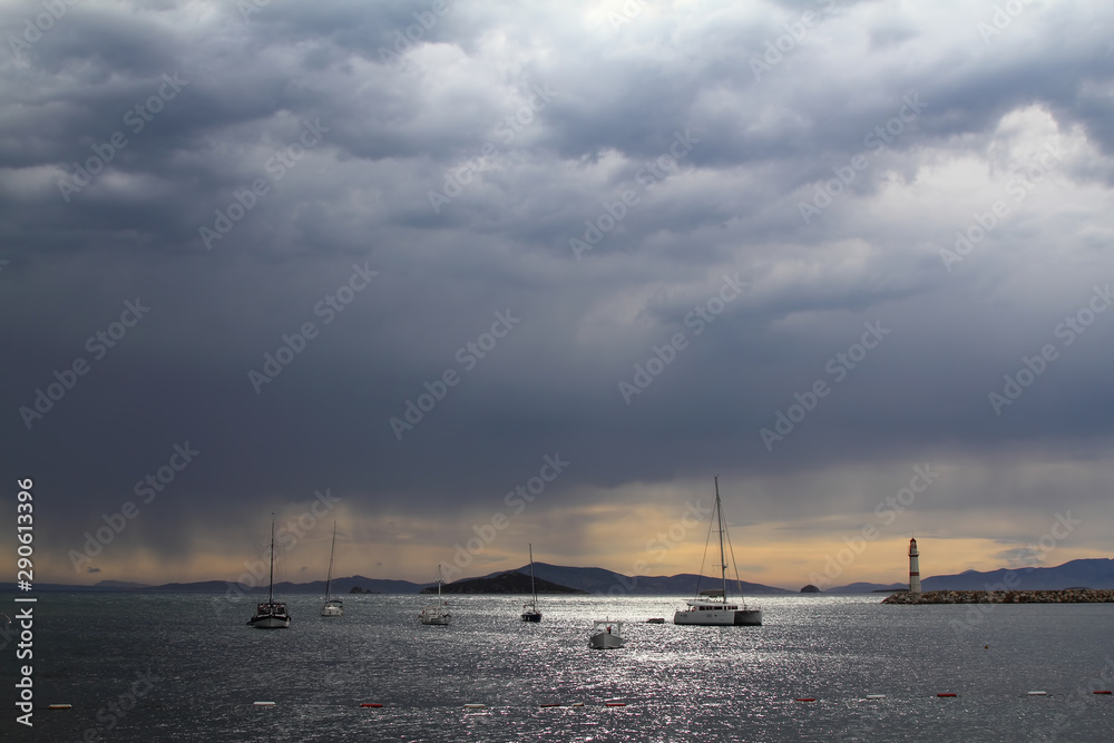 Heavy, storm clouds over the ocean, herald the arrival of a storm. Beautifully illuminated dark clouds and reflections in the ocean water Heavy, storm clouds over the ocean, herald the arrival of a storm. Beautifully illuminated dark clouds and reflections in the ocean water
