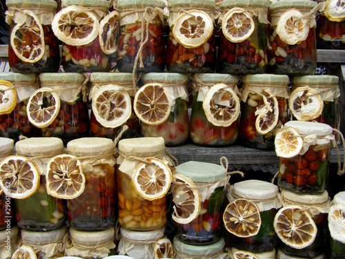 Honey with nuts in jars decorated with dried lemon.  © Olena