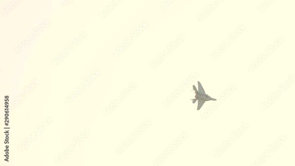 A reactive plane flying in the sky and performing a show - getting lost in the white bright sky