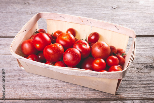 ripe tomatoes in a small wooden crate