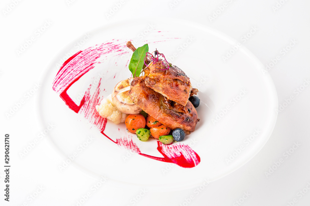 Grilled quail in a sauce with vegetables and berry confiture. Banquet festive dishes. Fine dining restaurant menu. White background.