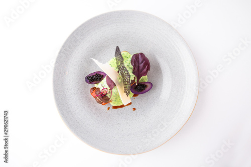Salmon fillet in a sauce with vegetables, caviar, octopus and mussels. S. Banquet festive dishes. Fine dining restaurant menu. White background.