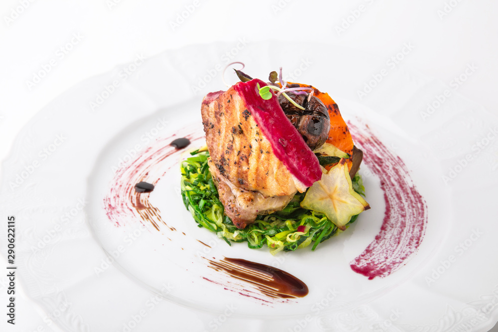Tender grilled pork meat, vegetables and berry sauce. Banquet festive dishes. Gourmet restaurant menu. White background.