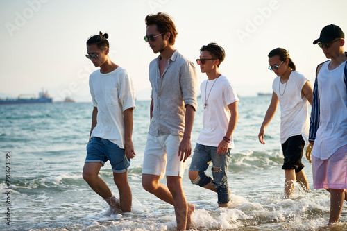 Photography group of asian men walking on beach