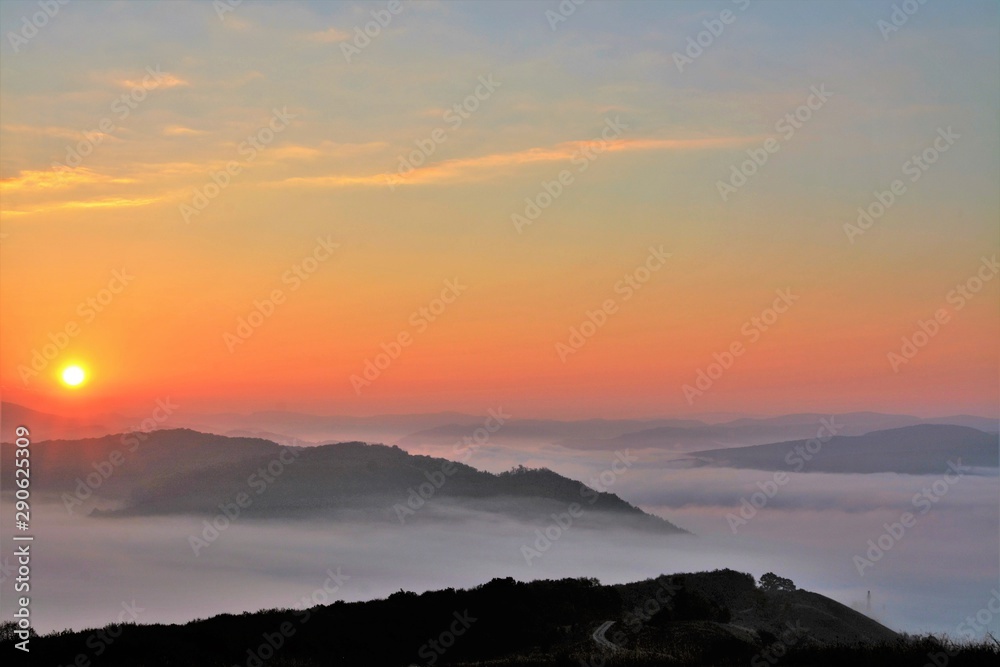 sunrise over mountains with fog in the valley