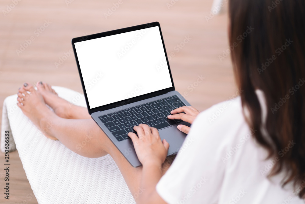 Mockup image a woman using and typing on laptop computer while sitting at terrece Mockup image a woman using and typing on laptop computer while sitting at terrece