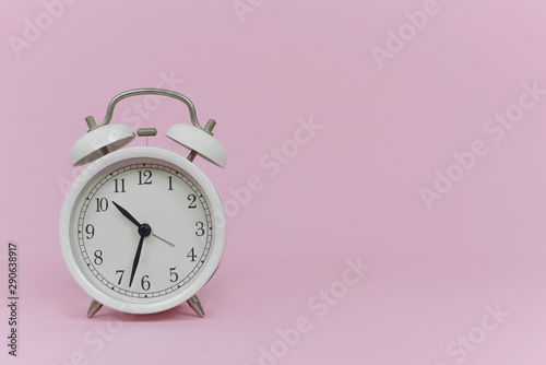 vintage alarm clock isolated on a pink background
