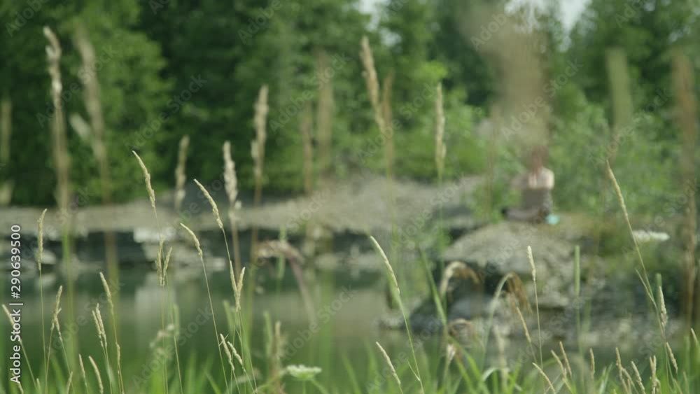 Middle aged woman practicing yoga relaxation on the shore of a lake Middle aged woman practicing yoga relaxation on the shore of a lake