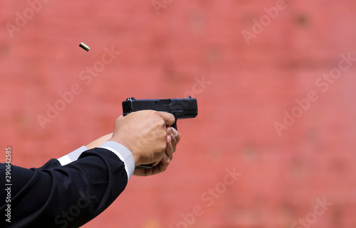 Closeup view of hand holding a pistol / handgun taking aim for target