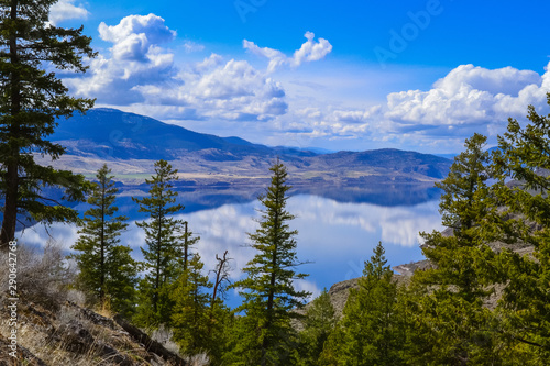 View of kamloops lake from Battle Bluff hike, clouds and mountains are reflecting in the calm lake, rocks photo