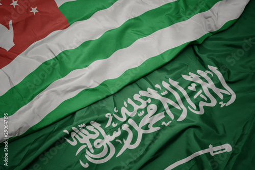 waving colorful flag of saudi arabia and national flag of abkhazia.