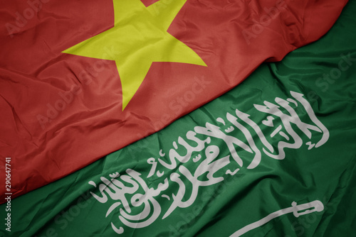 waving colorful flag of saudi arabia and national flag of vietnam.