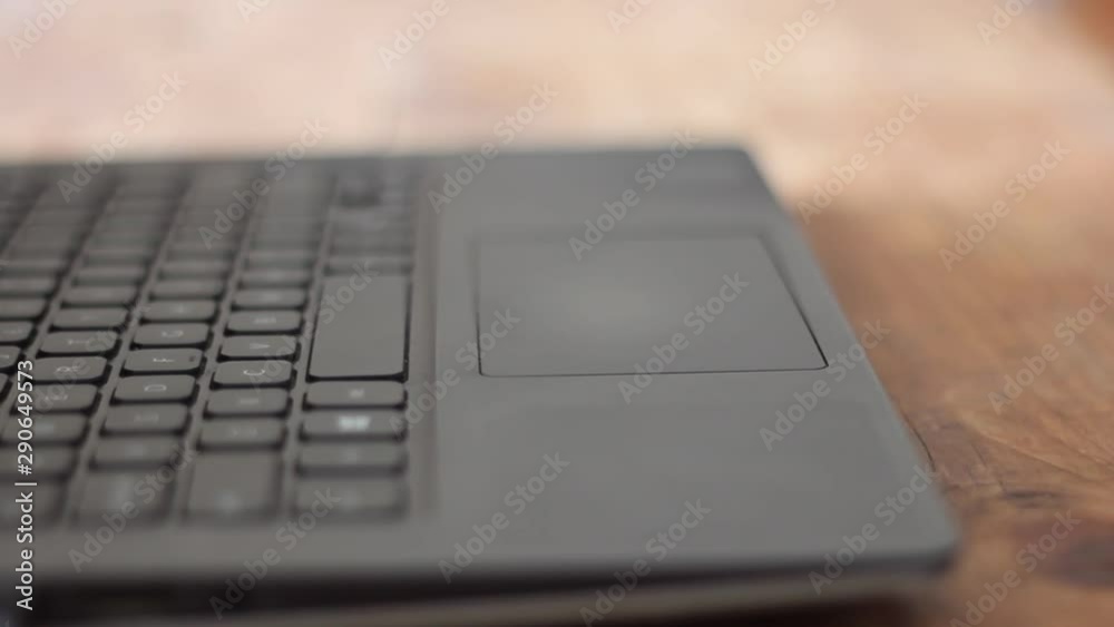 Closeup shot of notebook/laptop keyboard and screen on a wooden disk/table with slow motion pan of camera. Closeup shot of notebook/laptop keyboard and screen on a wooden disk/table with slow motion pan of camera.