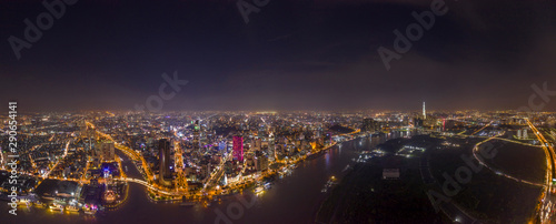 Ultra high resolution aerial panorama of Ho Chi Minh City or Saigon Vietnam under lights at night featuring all Landmark Buildings and Saigon River
