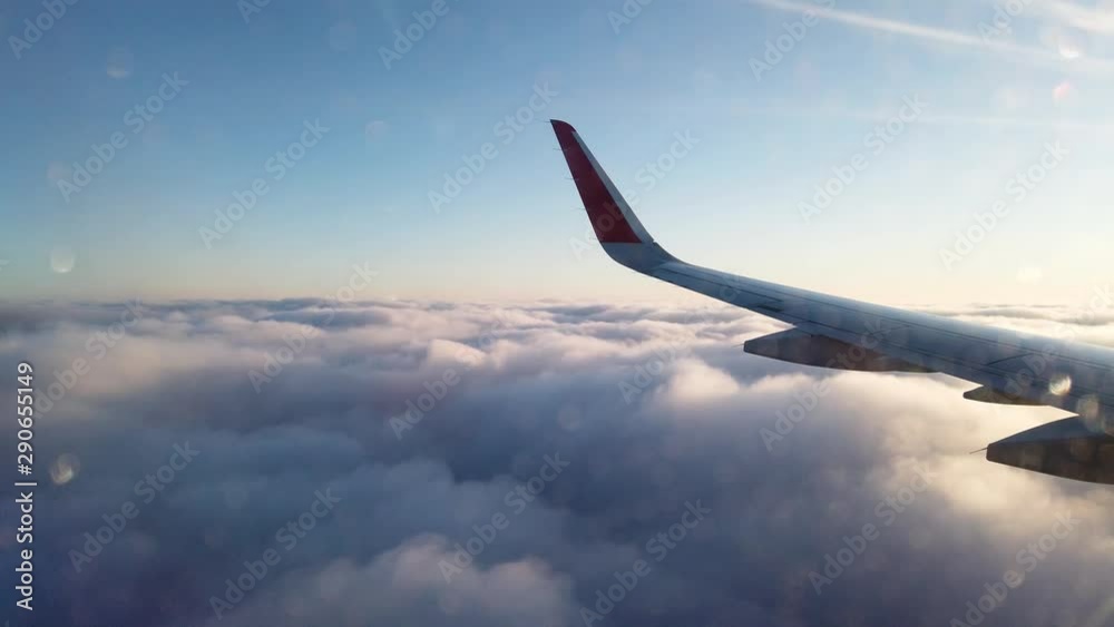 View from the porthole of an airplane. Flying at high altitude over an even layer of clouds. Early morning. View from the porthole of an airplane. Flying at high altitude over an even layer of clouds. Early morning.