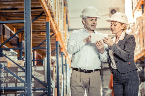 Delighted young woman working together with her colleague