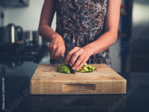 Young woman chopping avocado photo