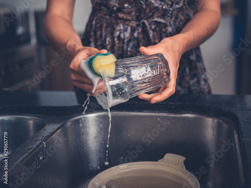 Young woman cleaning the dishes in her kitchen photo