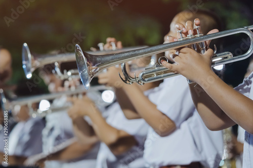 Photography Male student with friends blow the trumpet with the band for performance on stage at night