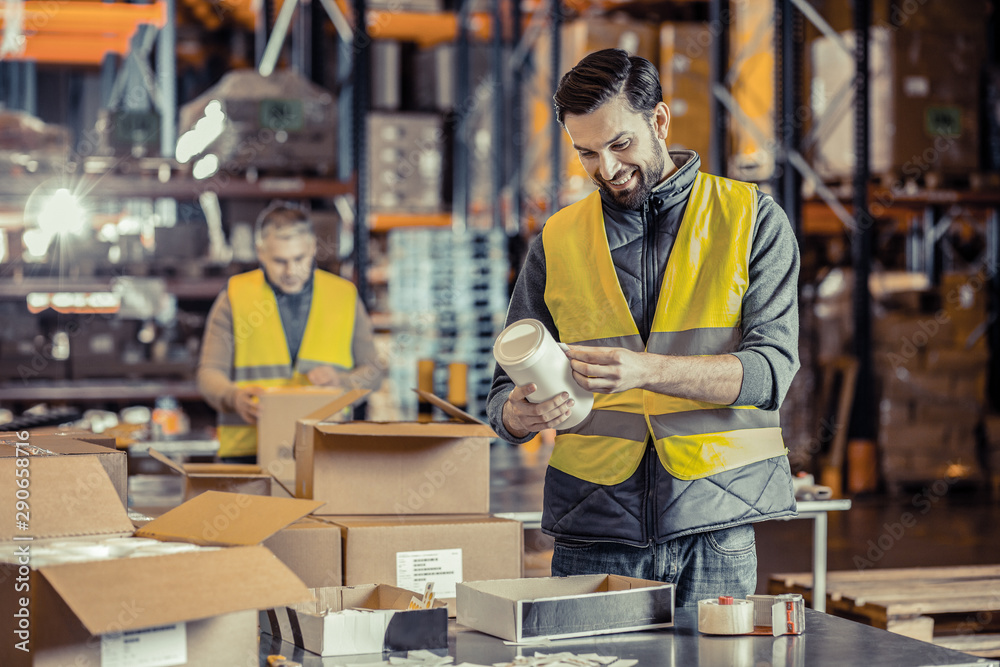 Cheerful bearded male person looking at goods Cheerful bearded male person looking at goods