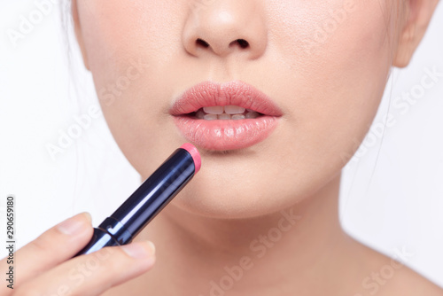 Pretty asian woman applying lipstick  isolated on white