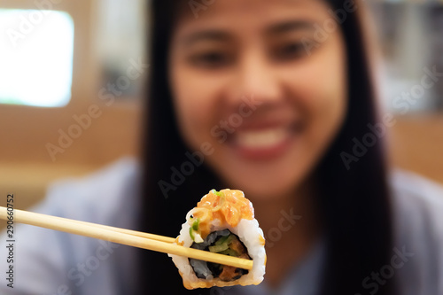 Asian woman happy traditional Japanese food sushi roll