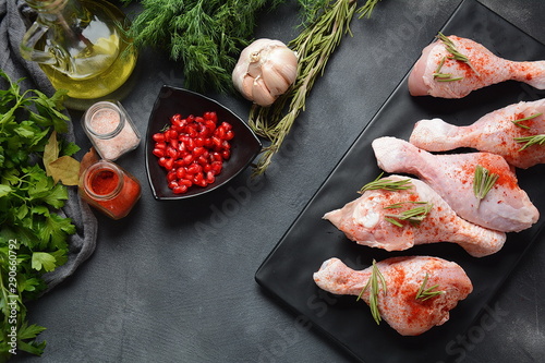 Raw uncooked chicken legs for barbecue grill with salt, herbs, garlic and olive oil. Meat with ingredients for cooking