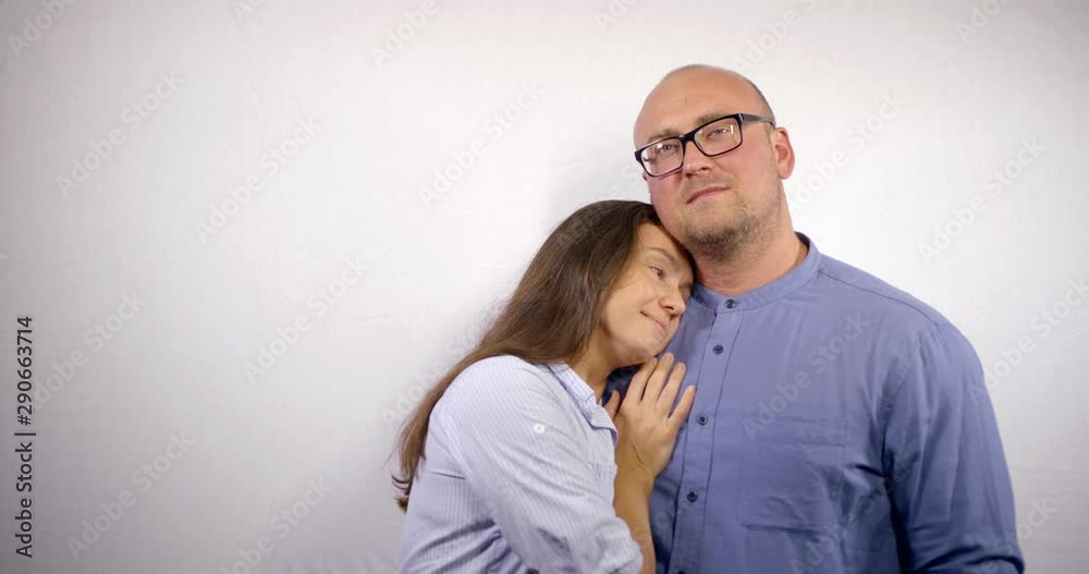Beautiful romantic adult couple isolated on white background. Attractive middle aged woman and handsome big bald man with glasses hug and love Beautiful romantic adult couple isolated on white background. Attractive middle aged woman and handsome big bald man with glasses hug and love