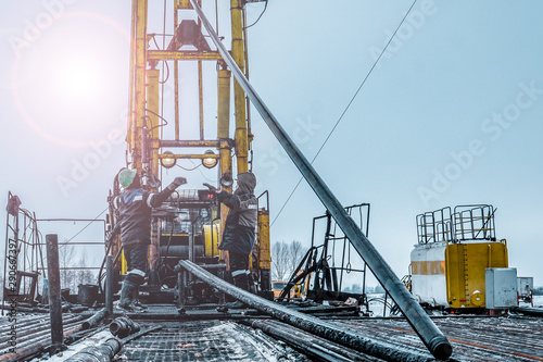 Offshore oil rig worker prepare tool and equipment for perforation oil and gas well at wellhead platform. Making up a drill pipe connection. A view for drill pipe connection from between the stands