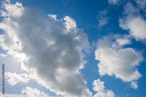 White clouds in a blue sky in sunlight at fall