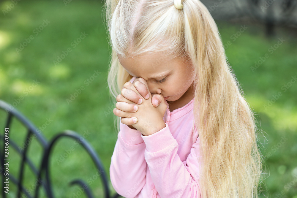 Cute little girl praying outdoors - obrazy, fototapety, plakaty 