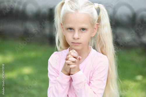 Cute little girl praying ou...