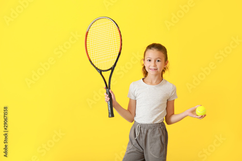 Little girl with tennis racket and ball on color background
