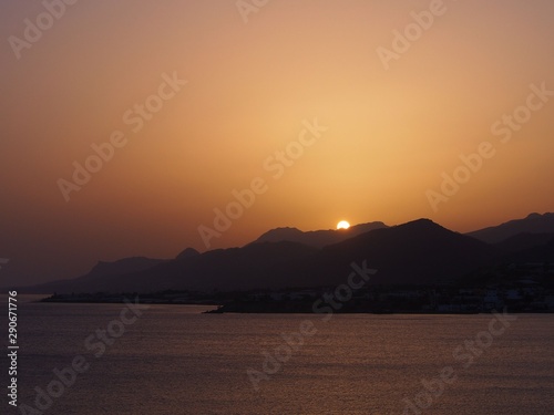 Orange-colored beach on the Greek island at sunset.
